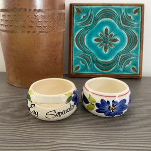Peut inclure: Deux séparateurs à œufs en céramique blanche avec des motifs floraux bleus. Un séparateur porte l'inscription "Egg Separator".