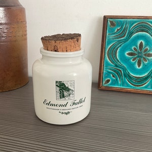 Może przedstawiać: Biały ceramiczny słoik z korkową pokrywką i zieloną etykietą z napisem "Edmond Fallot, Moutardier à Beaune Depuis 1840".