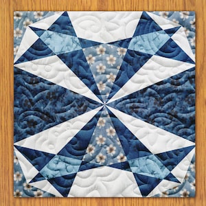 May include: A blue and white quilt with a geometric pattern. The quilt is made of fabric with a floral print.