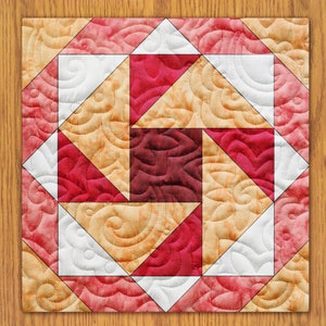 May include: A quilt block with a geometric pattern of red, white, and beige triangles. The fabric has a swirl pattern.