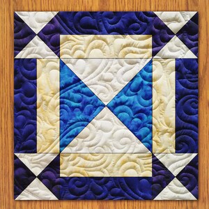 May include: A quilt block with a blue and white swirl pattern in the center, surrounded by a white and yellow swirl pattern, and a blue border with white triangles.