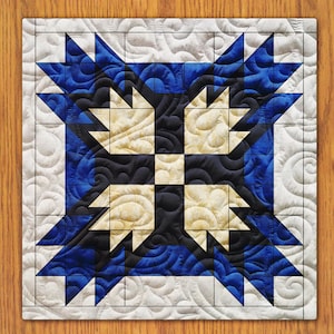 May include: A quilt block featuring a geometric design in blue, white and black. The block is composed of squares and triangles, with the pattern repeated throughout.