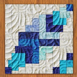 Puede incluir: Un bloque de colcha con un patrón geométrico de cuadrados azules y blancos. Los cuadrados están dispuestos en un patrón aleatorio, creando un diseño moderno y abstracto.