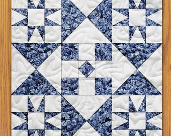 May include: A white quilt with a blue and white patterned design. The quilt is made up of nine squares, each with a different design. The center square is a simple white square, while the other squares feature a variety of geometric patterns.