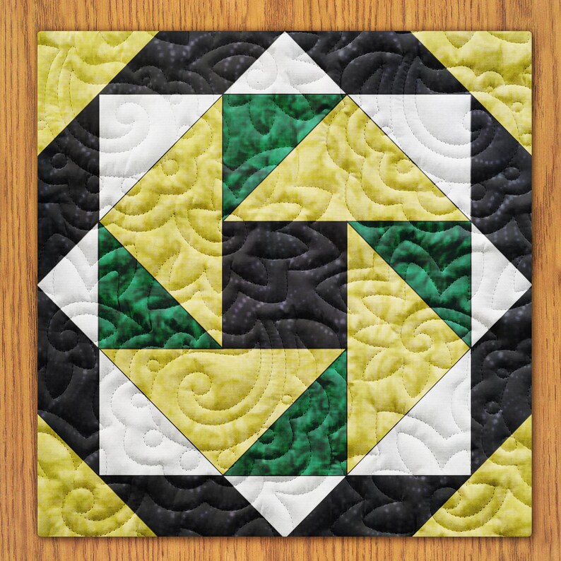 May include: A quilt block with a geometric design featuring black, white, green, and yellow fabric. The block is made up of triangles and squares, and the fabric has a swirl pattern.