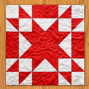 May include: A red and white quilt block with a star design. The star is made up of eight triangles, and the background is a repeating pattern of swirls.