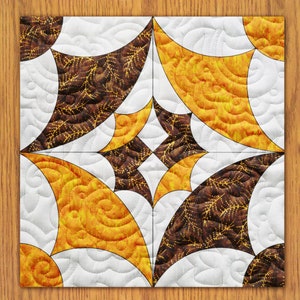 May include: A quilt block with a geometric design featuring curved shapes in brown, yellow, and white fabrics.