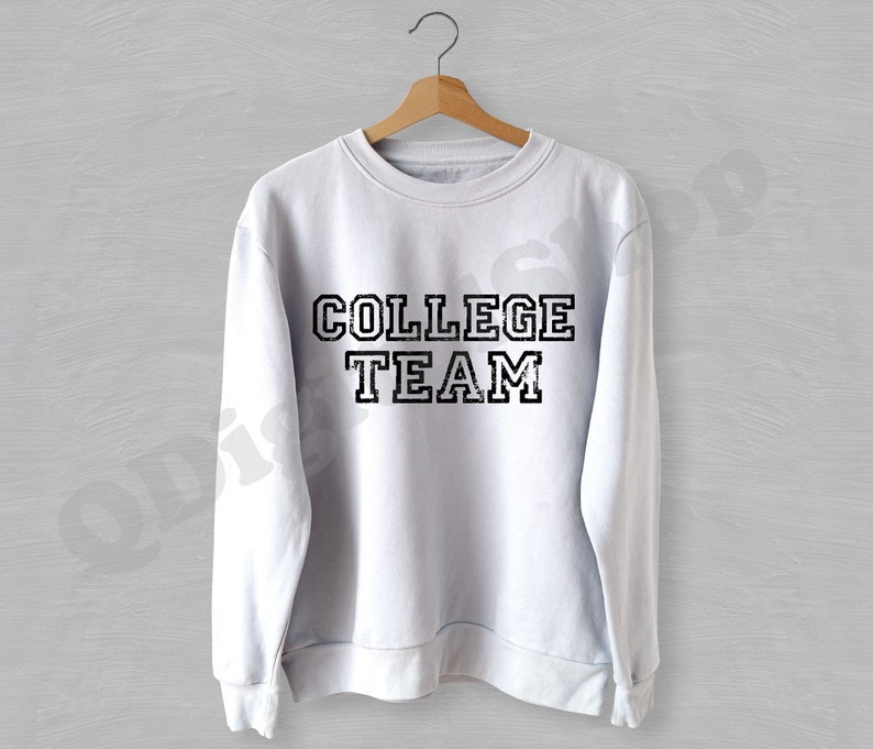 May include: White sweatshirt with a black distressed graphic that says "COLLEGE TEAM".