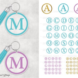 May include: Two keychains with a turquoise and a purple circle with a white letter M inside. The keychains have a turquoise and a purple tassel. The image also shows a chart of the alphabet with turquoise, purple, and gold circles with white letters inside.