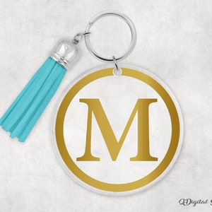 May include: A gold letter M keychain with a turquoise tassel. The letter is on a white circle with a gold outline.
