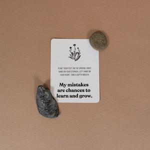 Może przedstawiać: Biała karta z czarnym tekstem i prostym rysunkiem kwiatu. Tekst brzmi "PLANT YOUR FEET ON THE GROUND RIGHT HAND ON YOUR STOMACH LEFT HAND ON YOUR HEART. TAKE A DEPTH BREATH. My mistakes are chances to learn and grow."