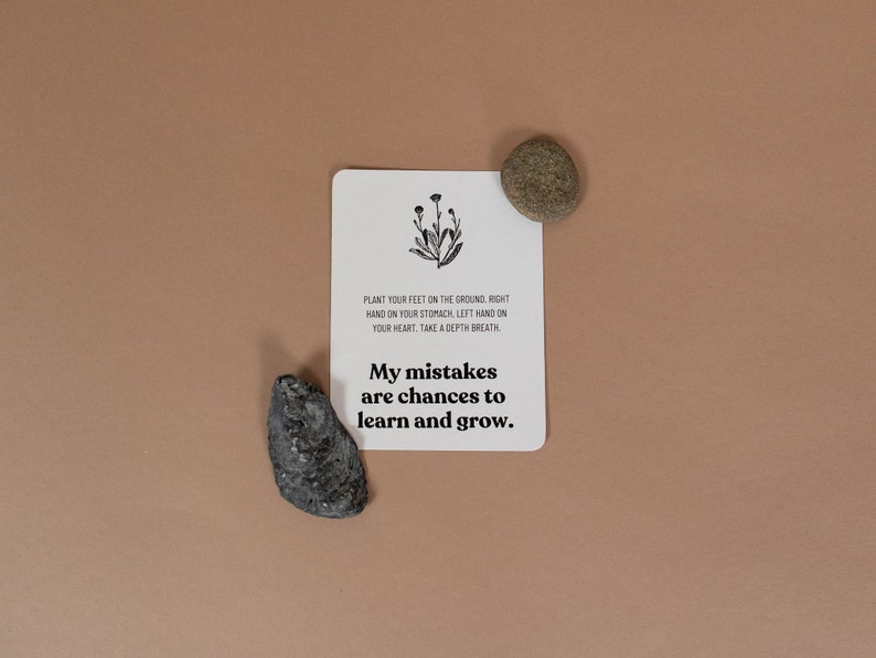 Może przedstawiać: Biała karta z czarnym tekstem i prostym rysunkiem kwiatu. Tekst brzmi "PLANT YOUR FEET ON THE GROUND RIGHT HAND ON YOUR STOMACH LEFT HAND ON YOUR HEART. TAKE A DEPTH BREATH. My mistakes are chances to learn and grow."