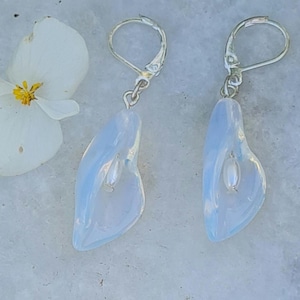 Könnte beinhalten: Ein Paar silberne Ohrringe mit einem weißen Opal-Stein in Form einer Blume. Die Ohrringe haben einen Hakenverschluss.