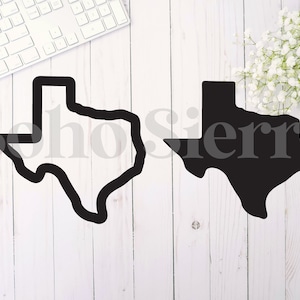 May include: Two black outlines of the state of Texas. One outline is filled in black, the other is empty. The outlines are on a white wooden background.