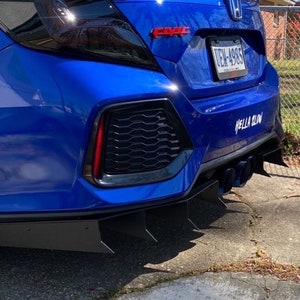 Peut inclure: Une Honda Civic bleue avec un diffuseur arrière noir et un autocollant "Hella Slow" sur le pare-chocs. La voiture a un aileron arrière noir et un pare-chocs arrière noir.