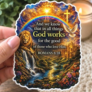 May include: A die-cut sticker featuring a vibrant landscape with a lion, a waterfall, a castle, a rainbow, and a dove. The text reads: And we know that in all things God works for the good of those who love Him. ROMANS 8:28, set against a sunset sky.