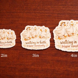 May include: Three stickers with a whimsical design of geese, each with the text "walking in faith trippin' constantly." The stickers are 2, 3, and 4 inches in size. The geese are depicted in a cartoon style, with one wearing a hat.
