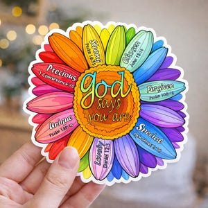 May include: A colorful sticker in the shape of a flower with rainbow petals. The center has the words "God says you are" in gold script. Each petal has a word like "Precious" and "Unique" with a Bible verse reference.