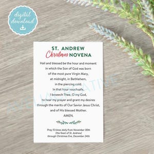 May include: A rectangular white card featuring the St. Andrew Christmas Novena prayer in black text with green and red accents. The text includes the prayer, instructions to pray 15 times daily from November 30th to December 24th, and a small floral graphic.