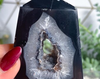 Peut inclure: Cristal d'agate noir et blanc avec une grande géode ouverte. Le cristal a la forme d'une pyramide et une surface lisse et polie.