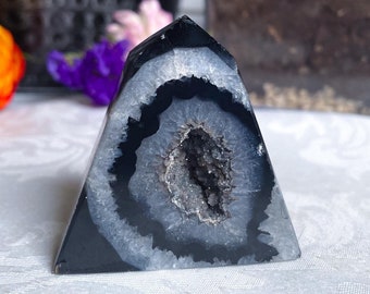 Peut inclure: Pyramide en cristal d'agate noir et blanc avec un centre creux. Le cristal est poli et a une surface lisse.