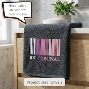 May include: A dark gray towel featuring an embroidered barcode design in shades of white, purple, and pink. Below the barcode, the text reads "BE ORIGINAL" in white and pink lettering. A speech bubble above the towel says "Get creative and use any color you like!" and a label below says "Project idea: towels".