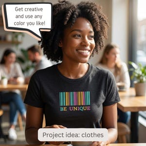 May include: A dark gray short-sleeved t-shirt featuring a colorful barcode graphic in teal, yellow, and pink, with the text "BE UNIQUE" printed below. A speech bubble above displays "Get creative and use any color you like!" and a label below reads "Project idea: clothes".