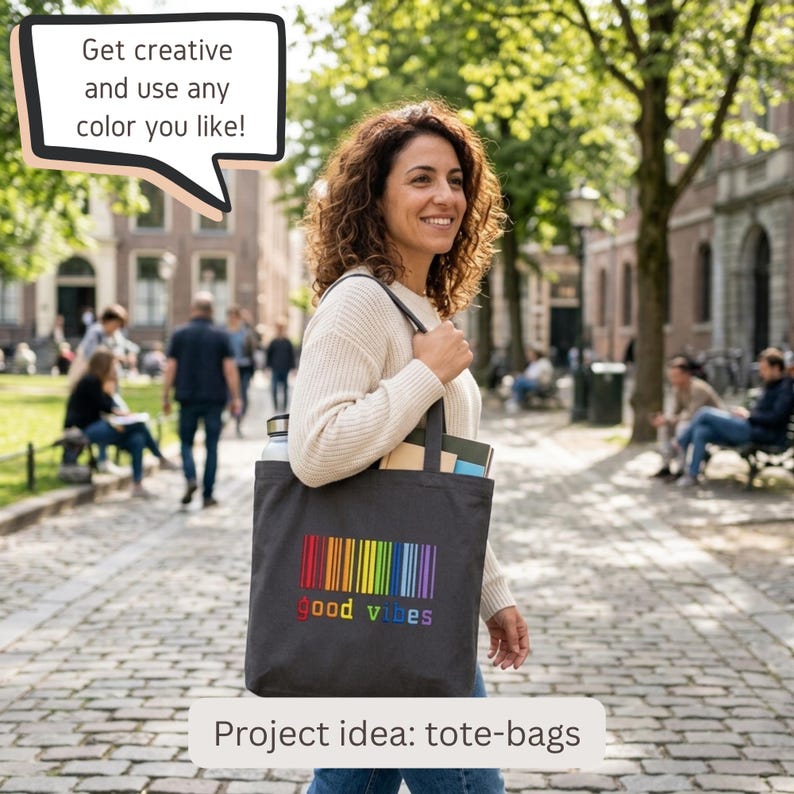May include: A dark gray tote bag featuring a colorful vertical rainbow barcode graphic above the text "good vibes" in rainbow-colored letters. The bag has two shoulder straps and contains a water bottle and notebooks inside the main compartment.