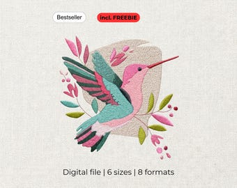 May include: An embroidery design featuring a pink and teal hummingbird in flight, surrounded by pink and green botanical elements. The design includes the text Bestseller and incl. FREEBIE at the top, and Digital file | 6 sizes | 8 formats at the bottom.