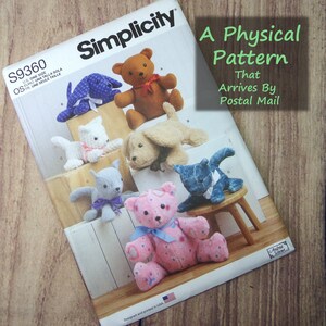 Pode incluir: Um envelope de molde de costura Simplicity S9360 com ilustrações de seis animais de pelúcia, incluindo ursos, gatos e cães em várias cores e tecidos. O texto diz A Physical Pattern That Arrives By Postal Mail e Designed and printed in USA.