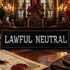 Könnte beinhalten: Ein schwarzes Patch mit dem in Weiß gestickten Schriftzug "LAWFUL NEUTRAL" auf einem Holztisch mit Gesetzbüchern, einem Stift und einem Wachssiegel. Der Hintergrund zeigt einen Gerichtssaal mit Thron und Buntglasfenstern.