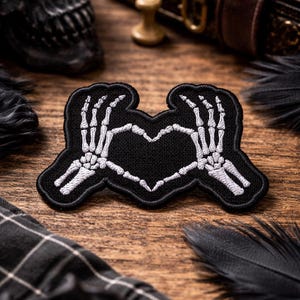 Könnte beinhalten: Ein Set aus drei Keramikbechern mit gesprenkelter, matter Oberfläche. Die Becher sind in Creme-, Hellgrau- und Dunkelgrautönen gehalten. Jeder Becher hat ein schlichtes, minimalistisches Design.