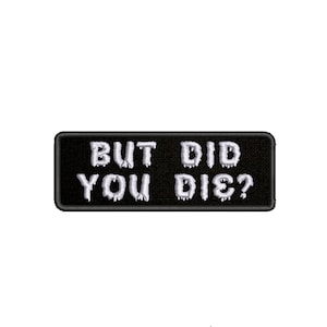 Peut inclure: Patch brodé noir et blanc avec le texte "BUT DID YOU DIE?" dans une police d'écriture qui coule.
