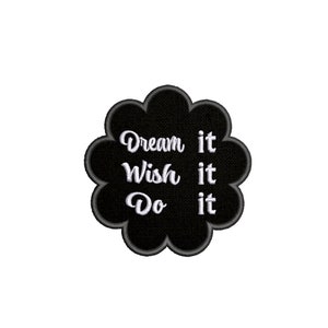 以下が含まれることがあります： 白と黒の刺繍パッチで、白い筆記体で「Dream it Wish it Do it」というテキストが書かれています。