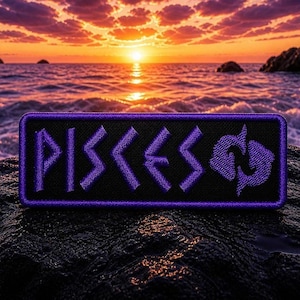 May include: A black rectangular patch with a purple border and the word "PISCES" embroidered in purple, along with the Pisces symbol. The patch is set against a sunset over the ocean.