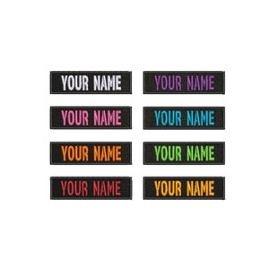 May include: Eight black rectangular patches with white stitching around the edges. Each patch has the text "YOUR NAME" in different colored thread: white, pink, orange, green, light blue, dark blue, yellow, and purple.