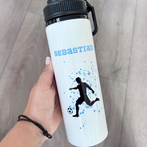 Gourde de football pour garçons, personnalisée avec le nom, le joueur de football masculin en action et un arrière-plan couleur splash. Cadeaux pour garçons.