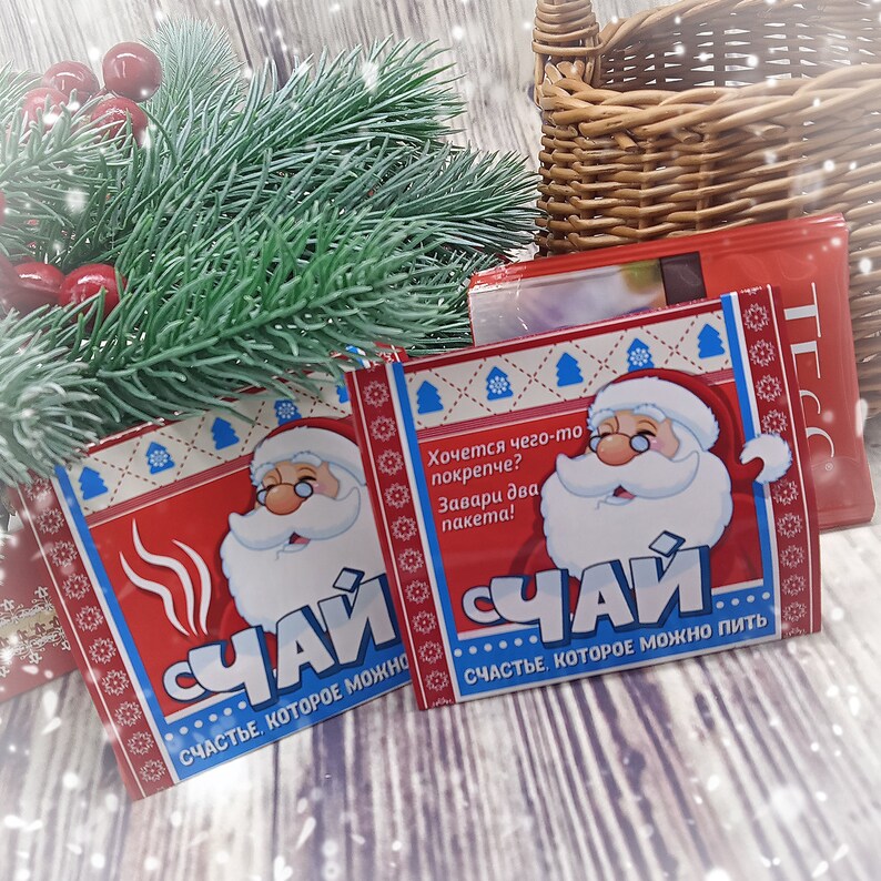 Puede incluir: Dos paquetes de t&eacute; instant&aacute;neo rojo y blanco con un Pap&aacute; Noel de dibujos animados en la parte delantera. El texto en el paquete dice "Хочется чего-то покрепче? Завари два пакета! СЧАЙ СЧАСТЬЕ, КОТОРОЕ МОЖНО пить".