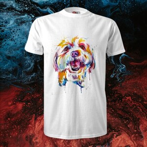 Op de afbeelding: Wit T-shirt met een kleurrijk aquarel schilderij van een hondenkop. De hond glimlacht en heeft een witte achtergrond.