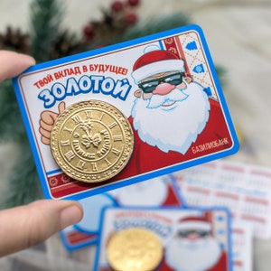 Puede incluir: Una tarjeta azul y roja con un Pap&aacute; Noel de dibujos animados que lleva gafas de sol. La tarjeta dice "&iexcl;Tu contribuci&oacute;n al futuro! Dorado" y presenta una moneda de oro con una esfera de reloj. La tarjeta tambi&eacute;n dice "Baziliobank" en la esquina inferior derecha.