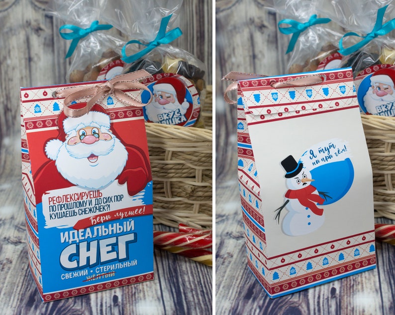 Puede incluir: Dos bolsas de regalo festivas con tem&aacute;tica invernal. Una bolsa presenta a un Pap&aacute; Noel de dibujos animados con el texto "Nieve ideal" y la otra presenta a un mu&ntilde;eco de nieve de dibujos animados con el texto "Estoy aqu&iacute; por la nieve".