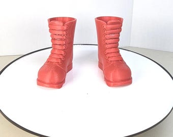 Könnte beinhalten: Ein Paar rote Schnürstiefel mit abgerundeter Spitze. Die Stiefel sind aus glattem, plastikähnlichem Material.