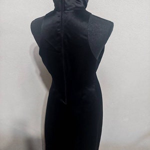 Puede incluir: Un vestido negro sin mangas con cuello alto y una cremallera en la espalda.