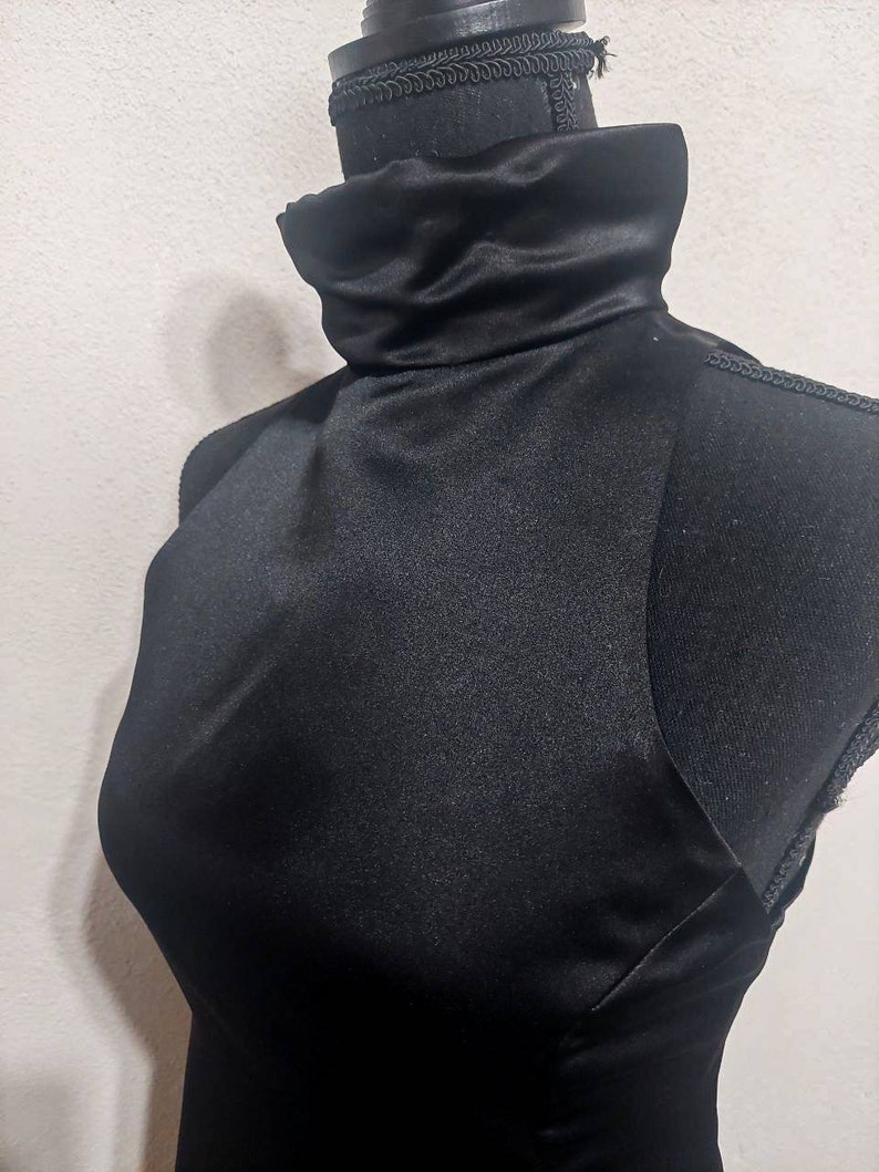 Puede incluir: Una camisa negra de cuello alto en un maniqu&iacute;.