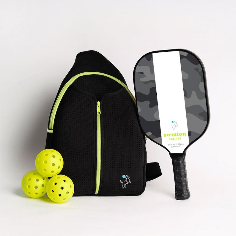 May include: A black and neon green pickleball bag with a black and gray camo pickleball paddle with the text "swinton eclipse USA PICKLEBALL APPROVED" and three yellow pickleballs.