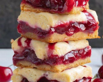 Pode incluir: Uma pilha de quatro barras de cheesecake de cereja com cobertura de cereja vermelha. As barras são feitas com uma crosta amanteigada, um recheio cremoso de cheesecake e uma camada de recheio de torta de cereja doce. As barras são cobertas com uma cobertura de cereja vermelha brilhante.