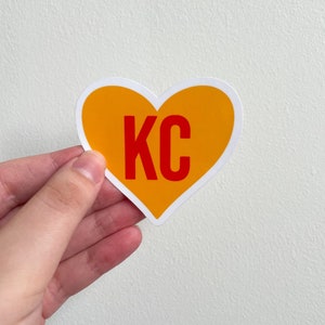May include: A yellow heart-shaped sticker with the letters "KC" in red.