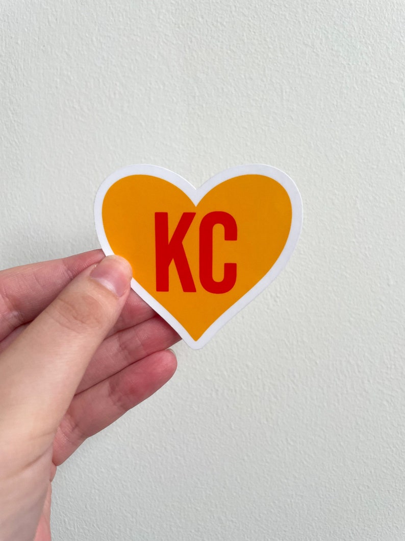 May include: A yellow heart-shaped sticker with the letters "KC" in red.