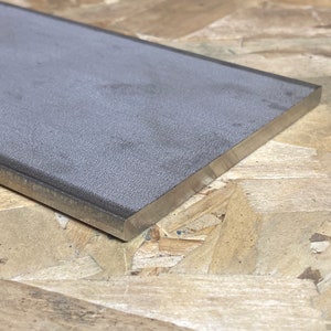 May include: A gray rectangular sharpening steel with a silver metal edge.