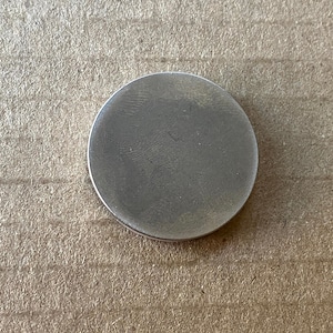May include: A silver-colored round metal disc.